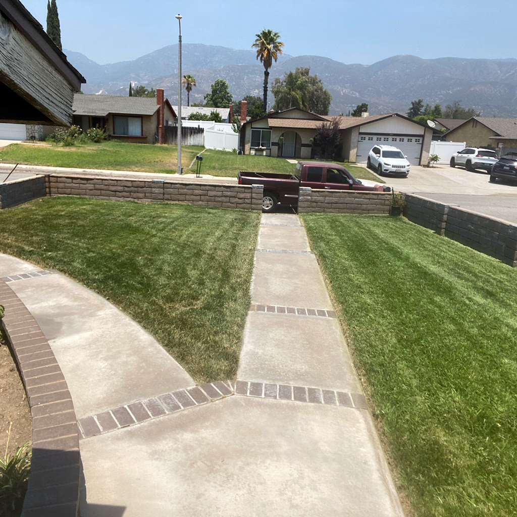 Freshly striped lawn framed by a brick bordered walkway and mountain views