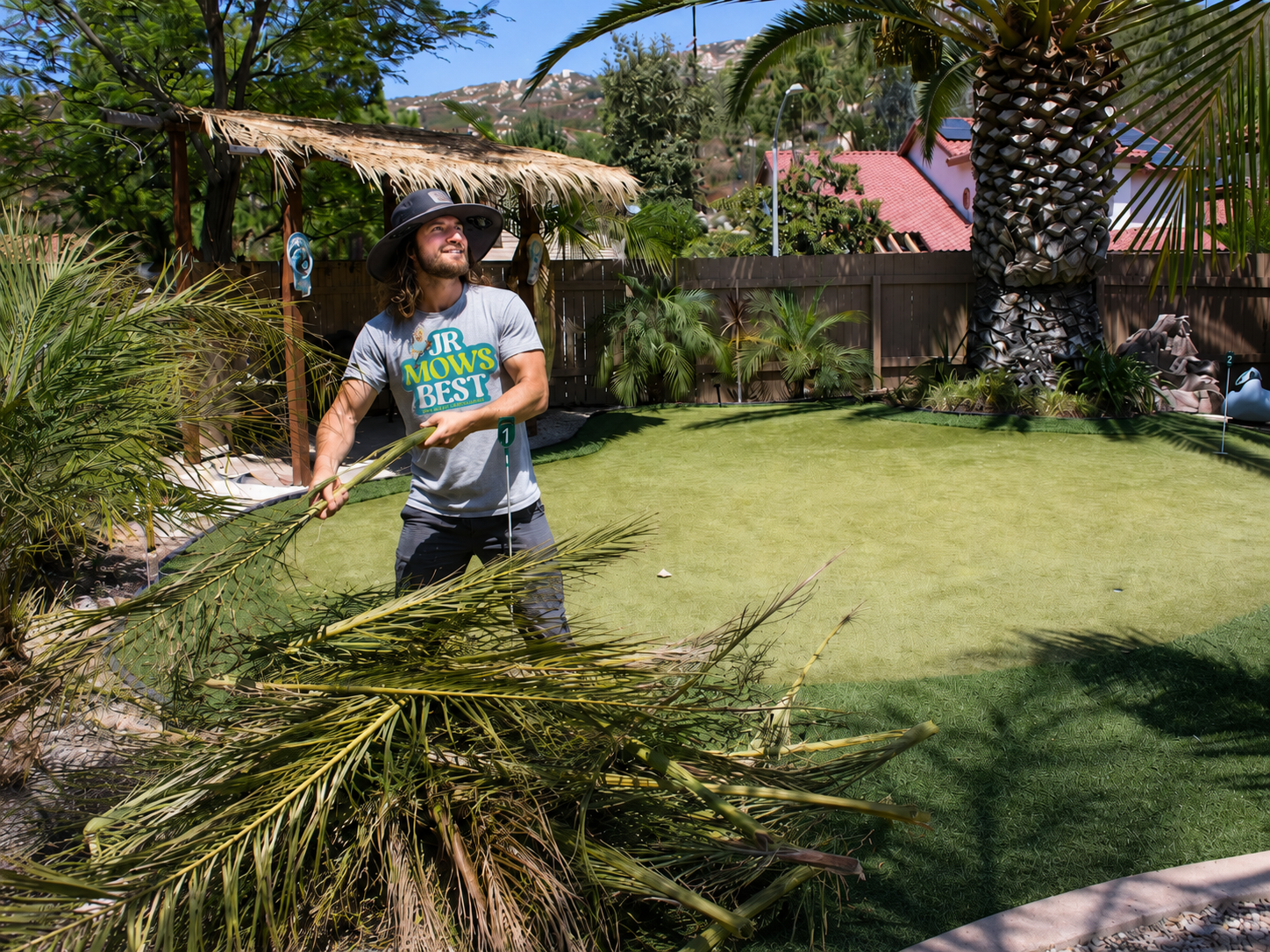 Jr clearing palm fronds and debris during a backyard deep clean-out at a San Diego home